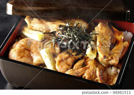 Hot charcoal-grilled yakitori with plenty of sauce, photographed against a black background 98981513