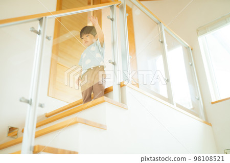 A 2-year-old boy walking down the stairs alone 98108521