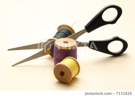 Thread bobbin and scissors on the white background 7133826