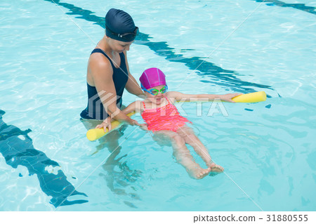 Female instructor training young girl in pool 31880555