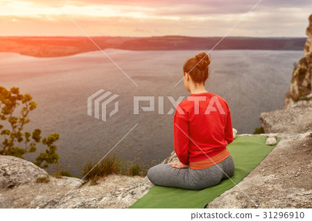 Rear view of young woman sitting in lotus position 31296910