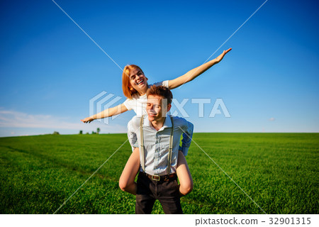 Smiling Man is holding on his back happy woman 32901315