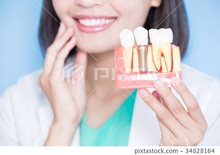 woman dentist take implant tooth 34828164