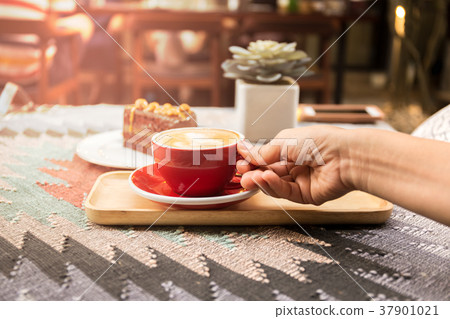 Hand with cup of coffee and chocolate cake  37901021