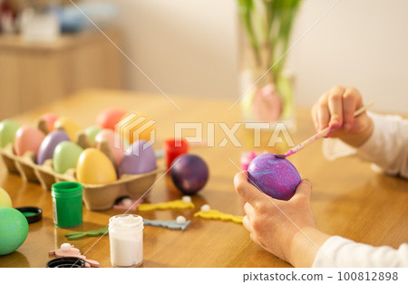 Child hands painting Easter eggs on wooden table. Happy Easter. Preparation for Easter celebration. 100812898