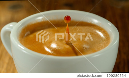 Macro Shot of Coffee Drop Falling into Fresh Espresso Cup 100280534