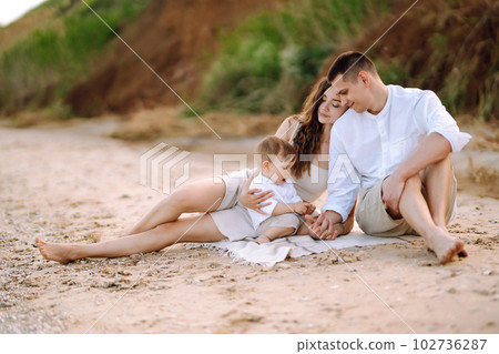 Cheerful young family with little baby boy spending time together on the beach. 102736287