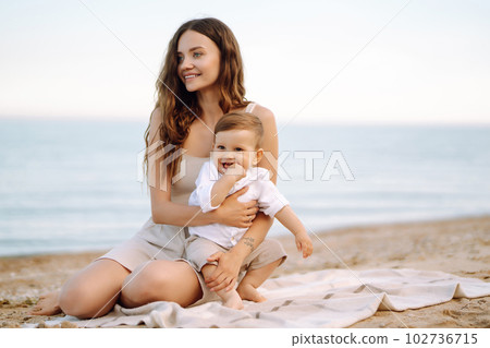 Beautiful mother and child resting on the beach. Active lifestyle. Happy childhood. 102736715