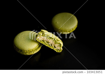 Exquisite Cut Green Pistachio Macaroon on Dark Background 103413051