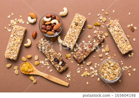 Various granola bars on table background. Cereal granola bars. Superfood breakfast bars with oats, nuts and berries, close up. Superfood concept 103604198