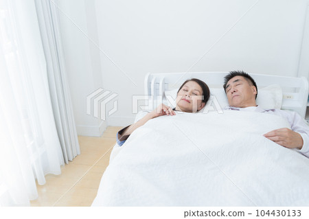 Elderly couple sleeping in bed (sleep/health) 104430133