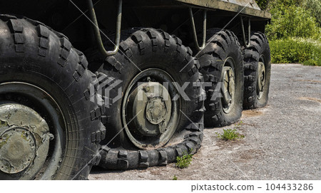 Flat and punctured wheels of armored personnel carriers during a military battle. Military conflict and weapons. 104433286