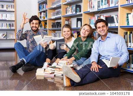 Students reading textbooks in public library 104503178