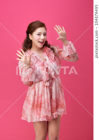 female model wearing a flower-patterned dress with a pink background and various poses 104876495