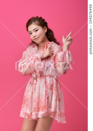 female model wearing a flower-patterned dress with a pink background and various poses 104876499