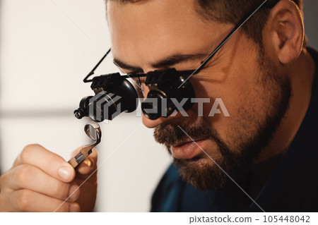 Jeweler working with ring on blurred background, closeup 105448042