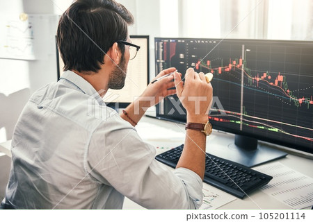 Successful trading. Back view of young bearded trader in formal wear pointing on the data on computer screen with pen and holding Bitcoin in one hand while working his modern office. 105201114