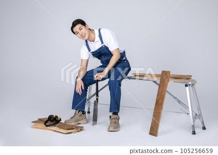 millennials and gen z, korean asian young man carpenter holding tablet pc 105256659