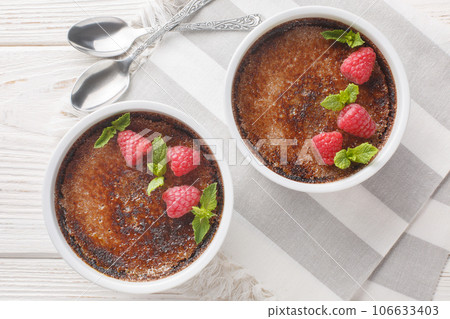 Holiday chocolate creme brulee with berry on top close-up in a ramekin. Horizontal top view 106633403