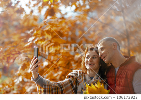 smiling romantic couple in park taking selfie 106172922