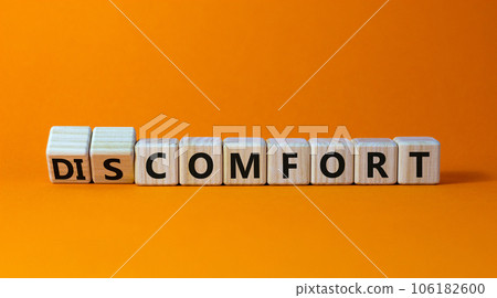 From discomfort to comfort symbol. Turned cubes and changed the word 'discomfort' to 'comfort'. Beautiful orange background, copy space. Business and from discomfort to comfort concept. 106182600