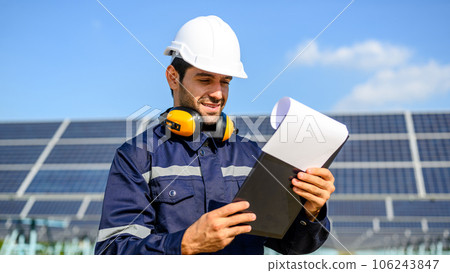 Technician worker installing solar panels at solar cell farm 106243847