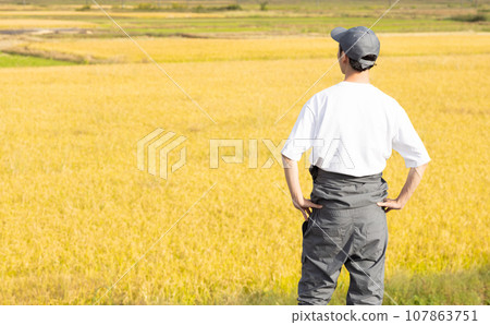 A refreshing man standing in a rice field 107863751