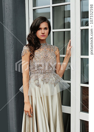 Perfect young adult model woman with makeup and wavy hairstyle in evening gown, fashion portrait 107332598