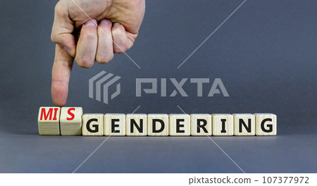 Gendering or misgendering symbol. Concept words Gendering Misgendering on wooden blocks. Beautiful grey table grey background. Psychologist hand. Gendering or misgendering concept. Copy space. 107377972