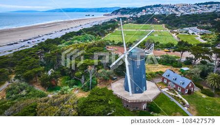 Murphy windmill beside small home and active soccer fields with city and ocean aerial 108427579