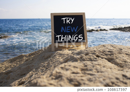 Try new Things symbol. Concept words Try new Things on black chalk blackboard blocks. Beautiful sea green background. Business and Try new Things concept. Copy space. 108617397