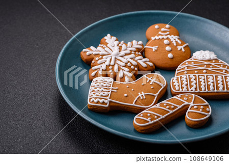 Beautiful Christmas gingerbread cookies of different colors on a ceramic plate 108649106