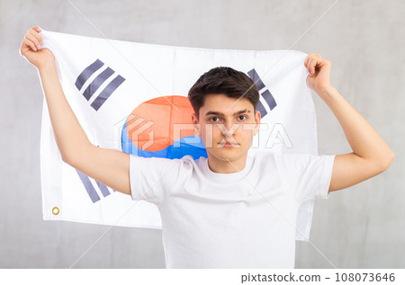 Focused young guy holding South Korea flag 108073646