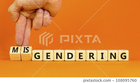 Gendering or misgendering symbol. Concept words Gendering Misgendering on wooden blocks. Beautiful orange table orange background. Psychologist hand. Gendering or misgendering concept. Copy space. 108095760