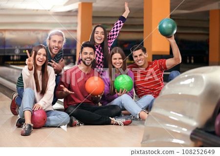 Group of friends with balls in bowling club 108252649