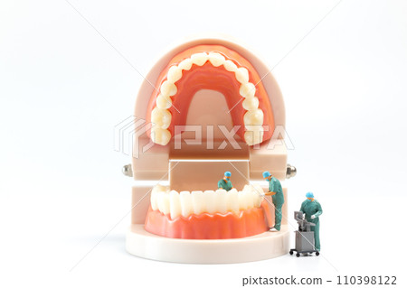 Miniature people , Dentist repairing human teeth with gums and enamel 110398122