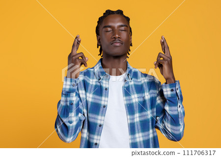 Making Wish. Portrait Of Young Black Man Keeping His Fingers Crossed 111706317