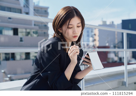 Business woman taking notes on the rooftop 111815294