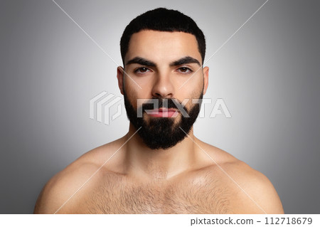 Closeup portrait of serious handsome young arab man on grey 112718679