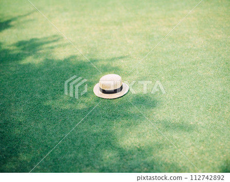 hat placed on green grass 112742892