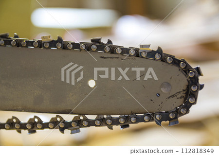 Closeup view of a chainsaw bar and cutting chain. 112818349