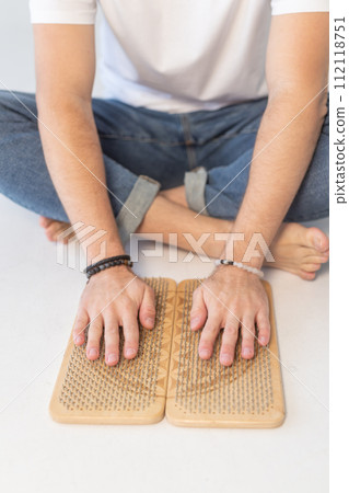 Sadhu board, yoga board with nails, guy stands on the board with nails, yoga concept 112118751