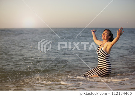 Rest at the resort. An elderly woman on vacation by the sea spread her arms. 112134460