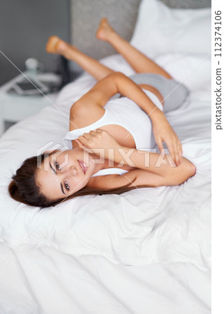 Casual, relax and portrait of woman in bed with wellness, confidence and happy in apartment. Morning, home and girl in bedroom with peace, calm and wake up for healthy sleep, comfort and natural rest 112374106