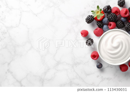 A bowl of ice cream with fresh raspberries and blueberries on top. 113430031