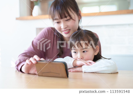 Parents and children using smartphones: girl and mother 113591548