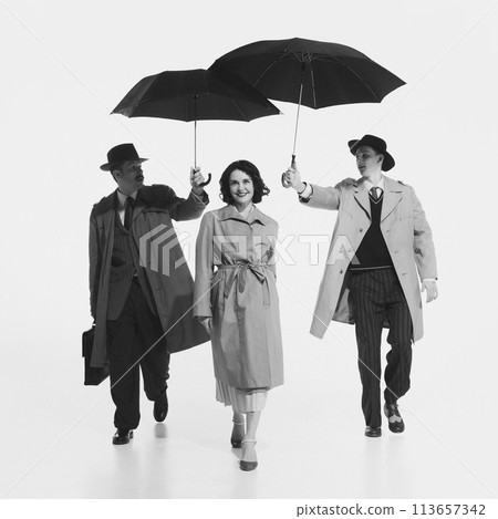 Black and white image of young beautiful smiling woman walking while tow man on background proposing her their umbrella. 113657342