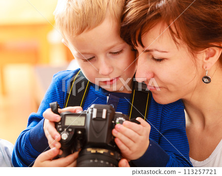 Mother and child playing with camera taking photo 113257721