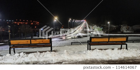 Two empty benches in winter park backdrop. Relax place near winter cityscape 114614067