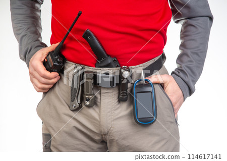 walkie-talkie, flashlight, knife, GPS navigator on the belt of the tourist trekking pants 114617141